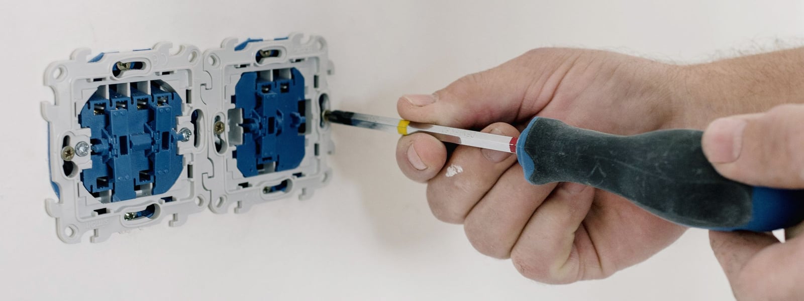 Appareillage électrique vétuste remplacé, mécanismes neufs vissés dans le mur
